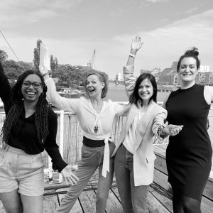 The four panelists in a celebratory pose Heather, Cathleen, Rita and Lea on a boat with the Berlin skyline in the background.