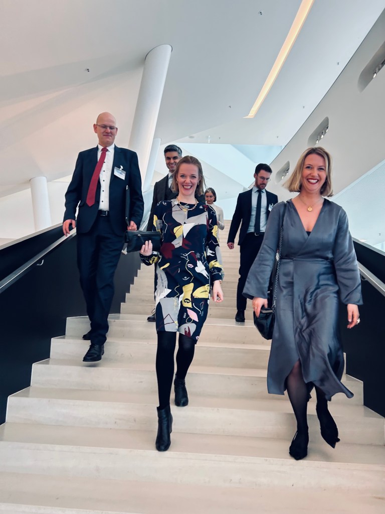 The Upgrade Democracy team walking down the stairs, all with smiles and dressed elegantly for the Reinhard Mohn Preis ceremony.